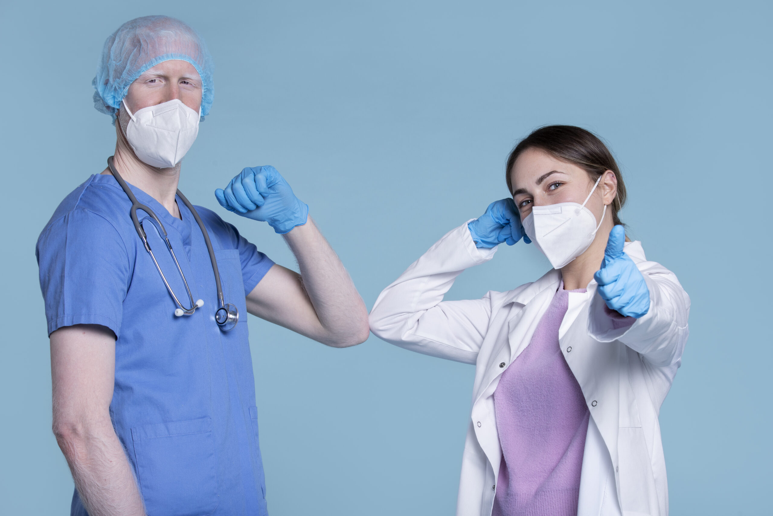 CRNA and anesthesiologist in PPE doing an elbow bump gesture